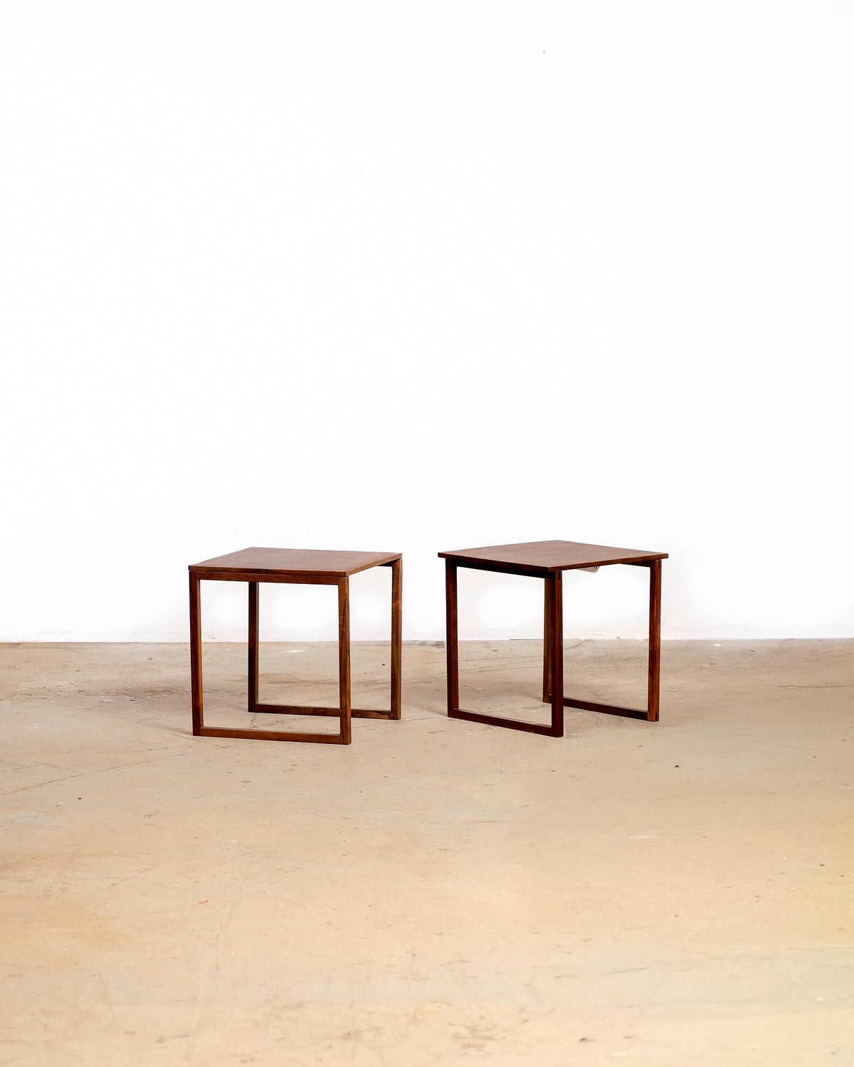Mid-century modern rosewood side table set on a plain white background — compact stacking design