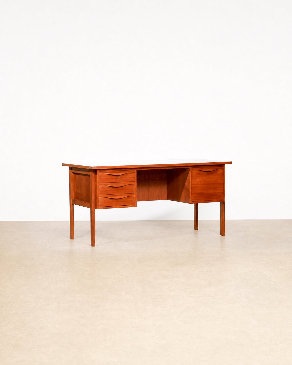 Mid-century modern Danish teak desk by LYBY Møbler on a plain white background — rich teak grain
