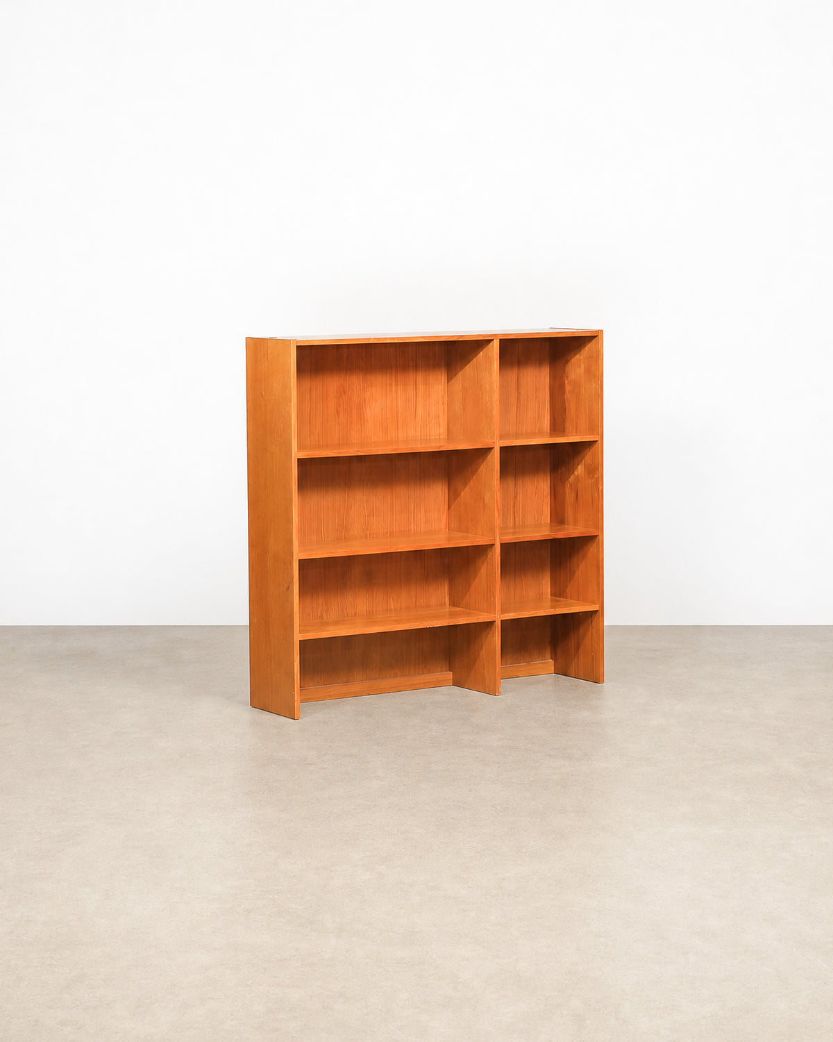 Mid-century modern Danish teak bookcase by Domino Møbler on a plain white background — versatile open shelving