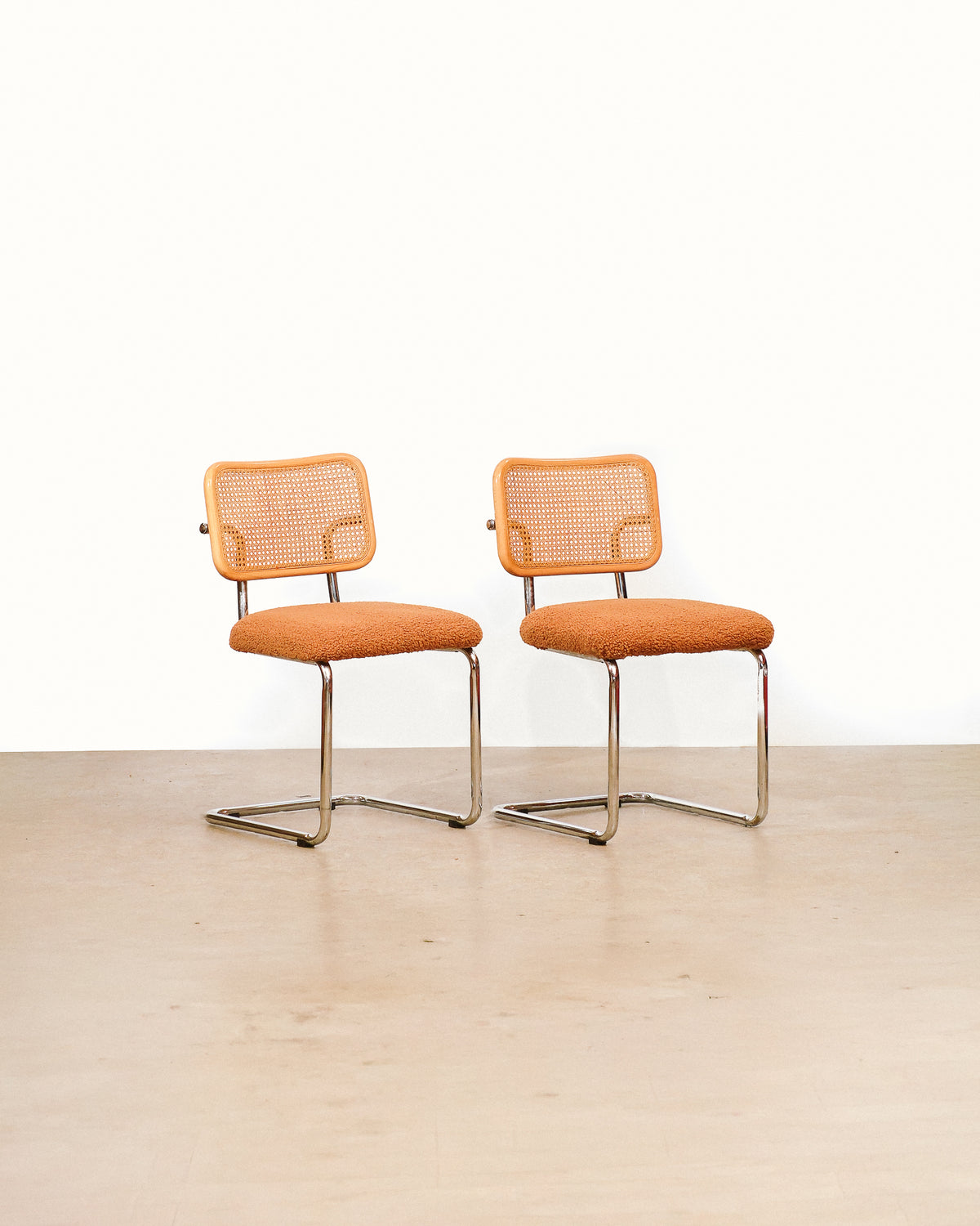 Cesca chair set with camel brown boucé fabric on a plain white background — cantilevered chrome frames