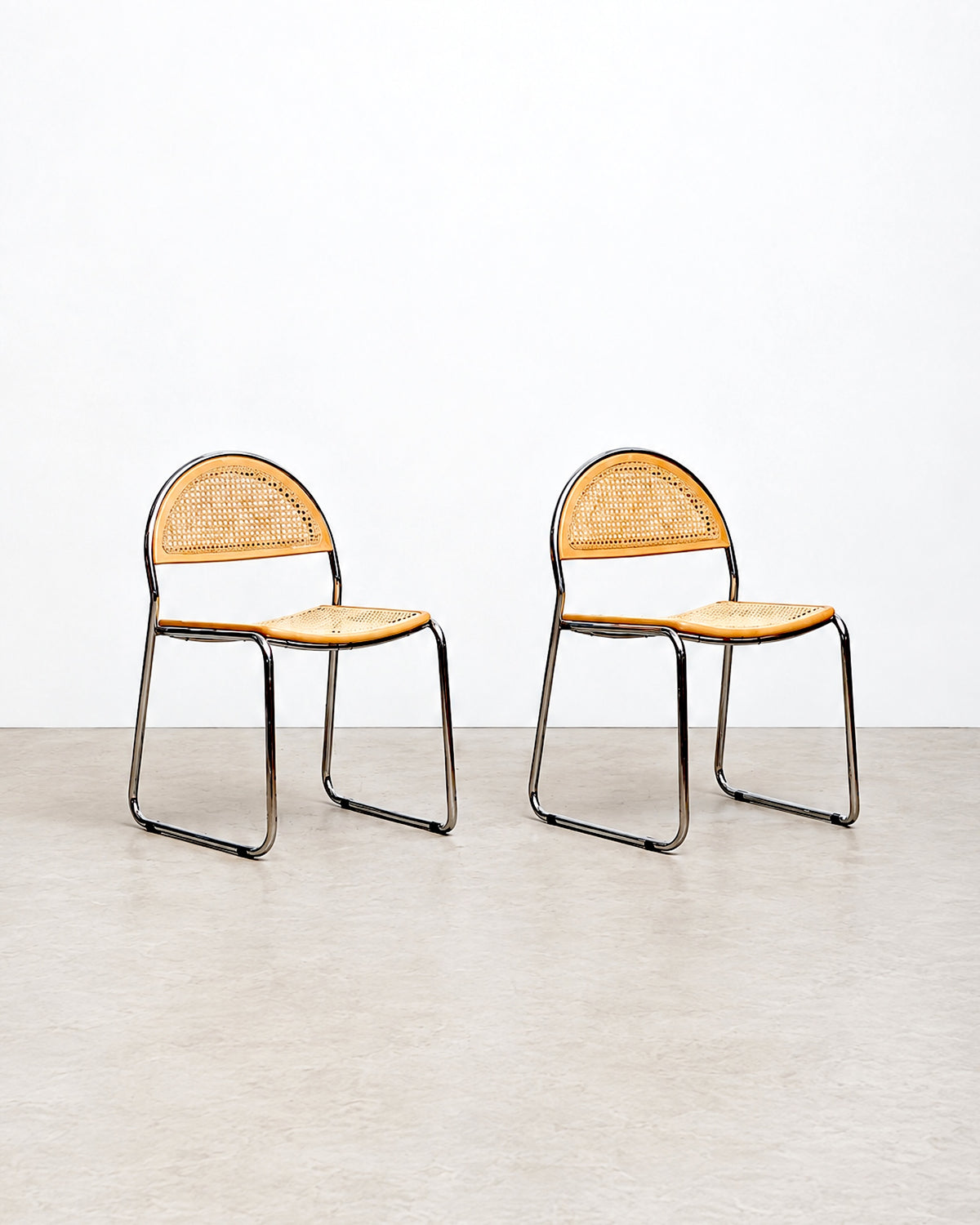 Studio side-by-side view of two cane chairs against a plain background