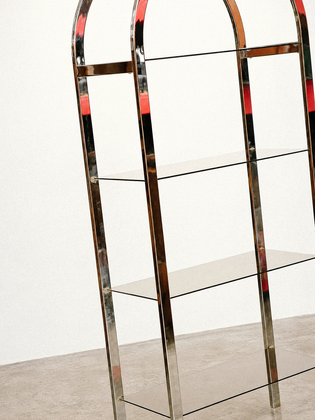 Detail view of the chrome frame and stacked smoked glass shelves from mid-height.