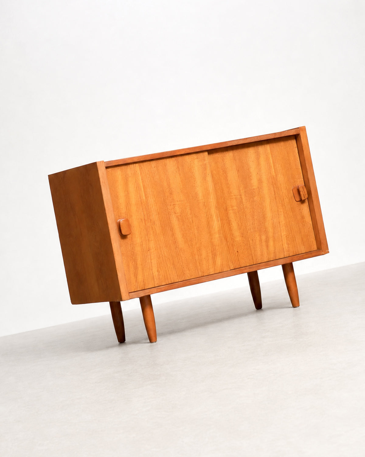 Front view of the teak cabinet showing both sliding doors closed.