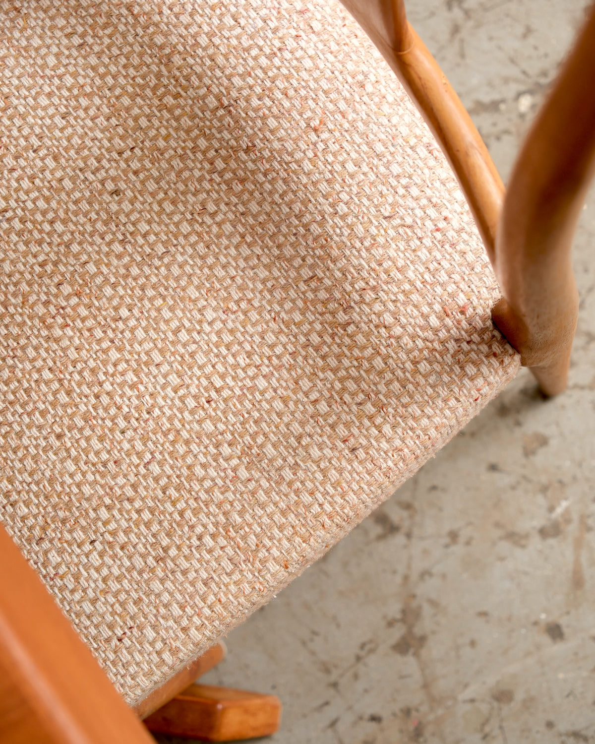 Overhead view of the tweed seat upholstery showing the woven texture and teak frame detail