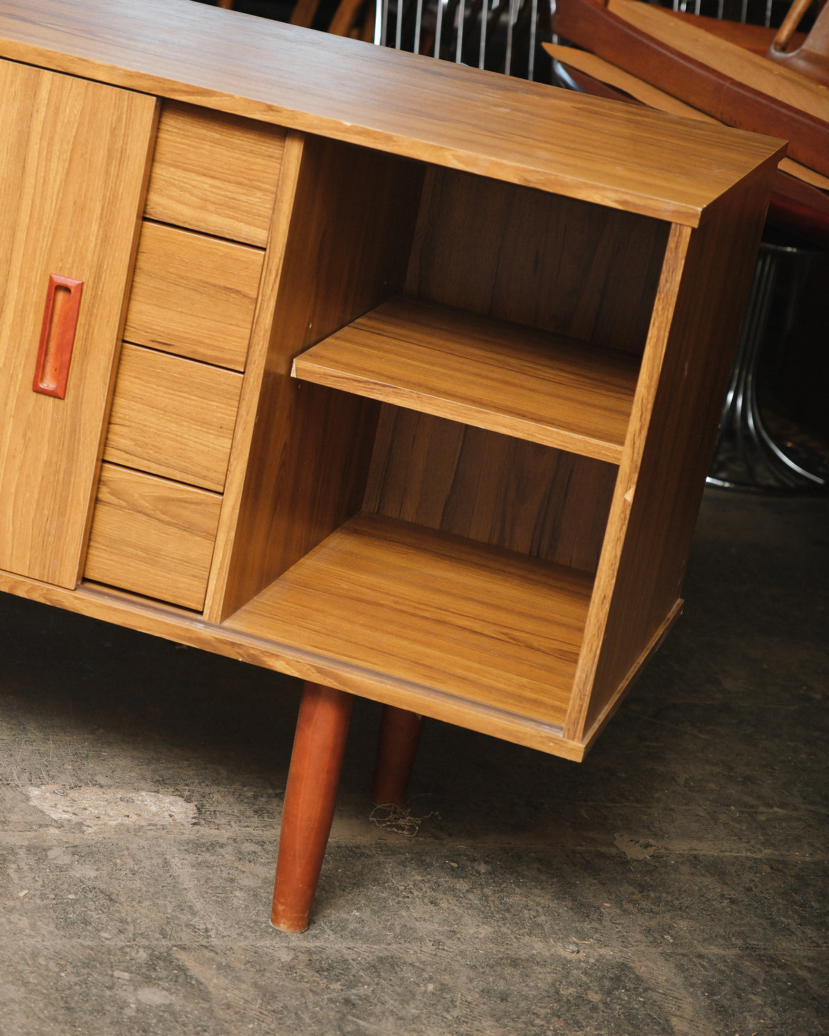 Angled view of the open shelving section beside the drawers, showing adjustable interior shelf.