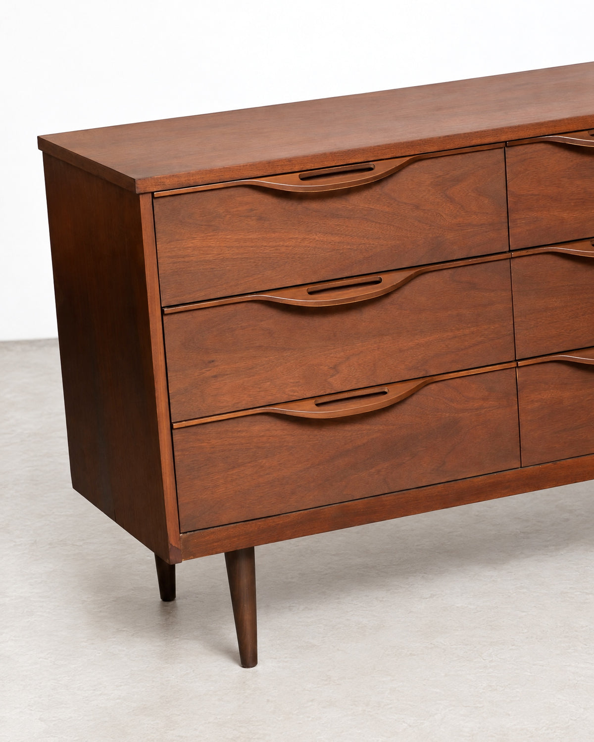 Close-up angled view of the left side drawers and tapered leg