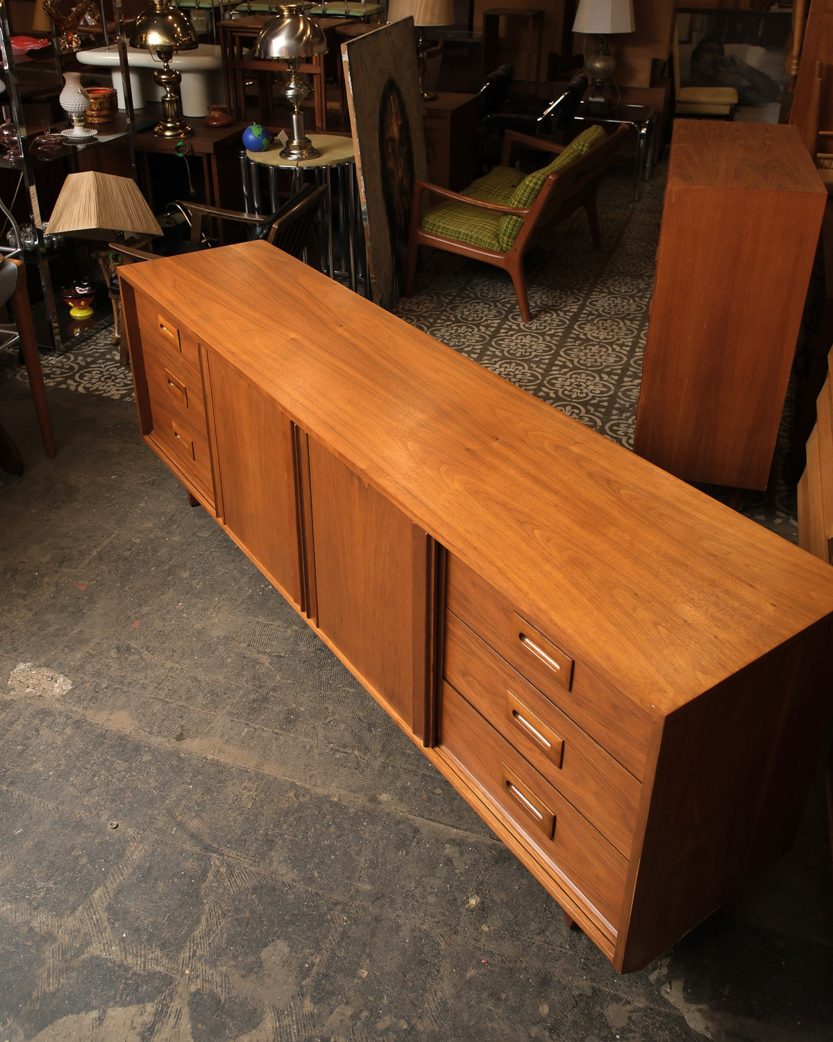 Three-quarter view of the sideboard highlighting the walnut grain, drawer pulls, and tapered legs.