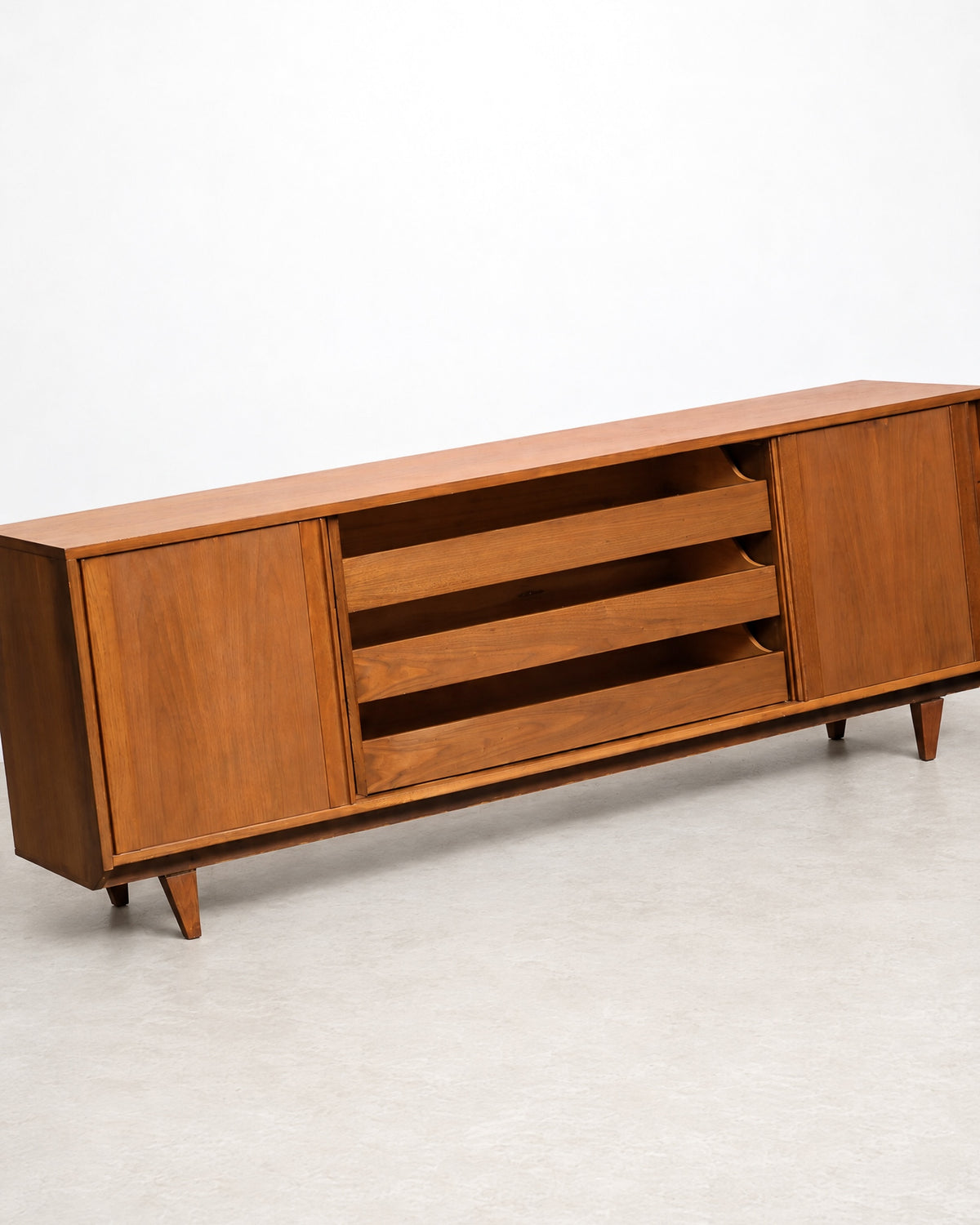 Rear three-quarter view of the sideboard with one sliding door open, revealing interior shelving.