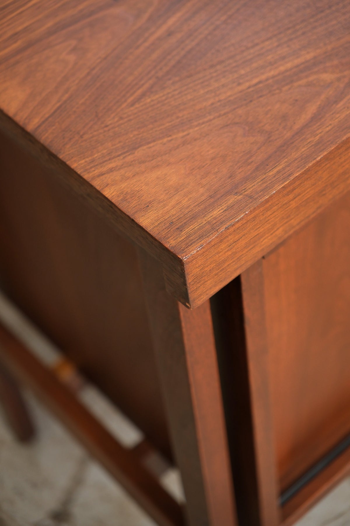 Close-up of the walnut grain and corner joinery on the top of the cabinet