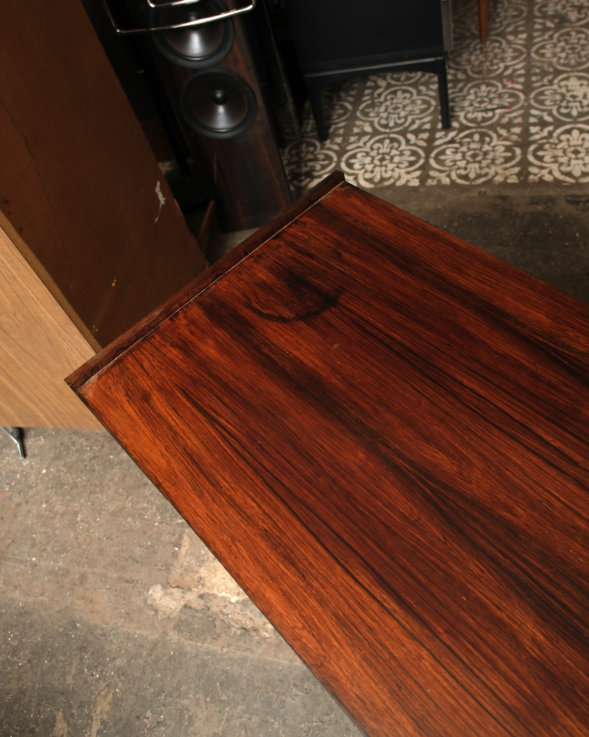 Close-up of the rosewood tabletop corner showing grain detail and a small surface mark