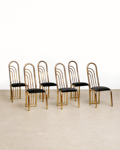 Wide view of several brass chairs arranged together showing the matching set.