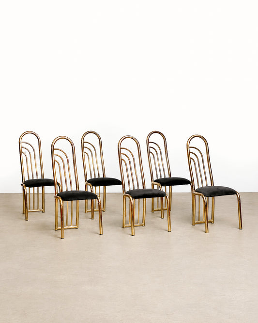 Wide view of several brass chairs arranged together showing the matching set.