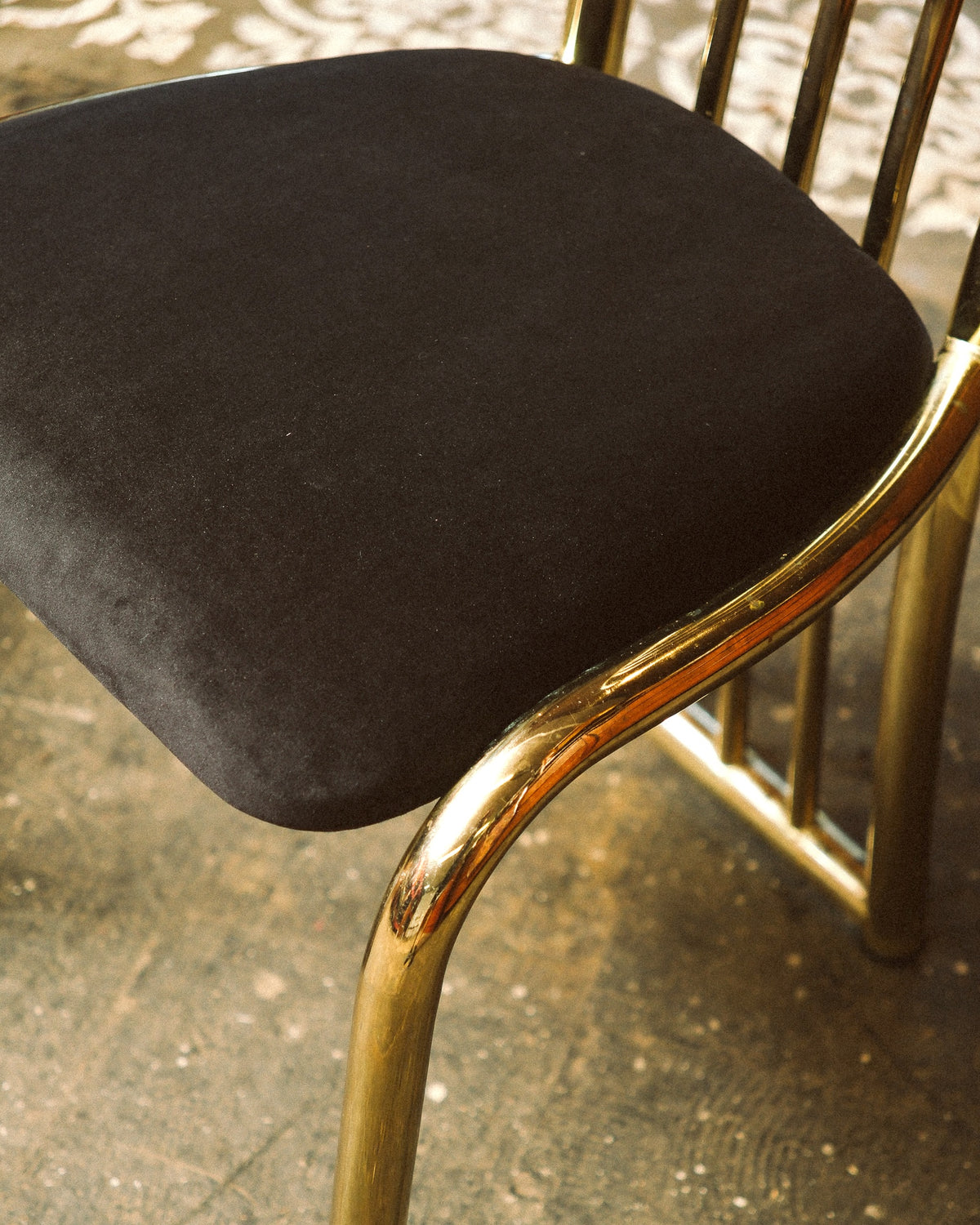 Overhead angle of the black velvet seat and brass backrest spindles.