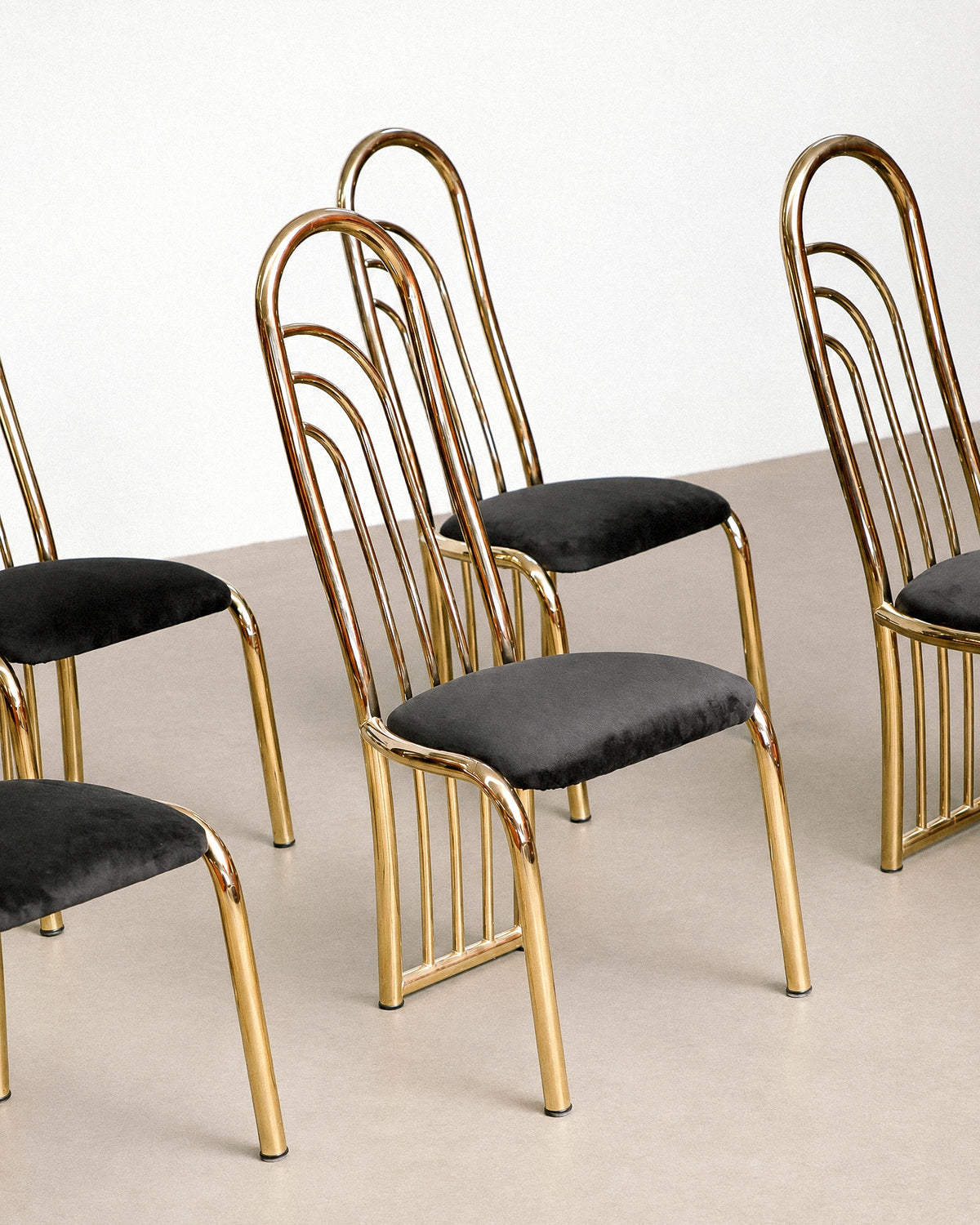Side profile of the chair highlighting the curve of the brass frame from seat to floor.