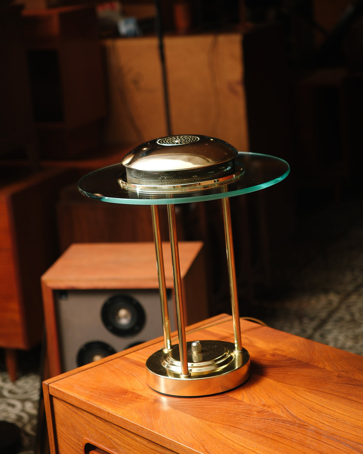Side angle of the brass saturn lamp showing the domed perforated top and glass disc.
