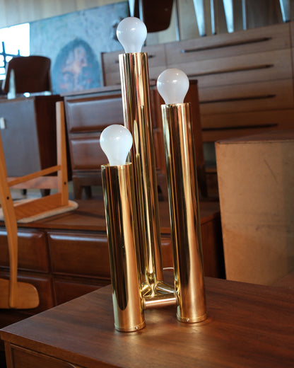Side view of the brass table lamp highlighting the varying tube heights and brass finish