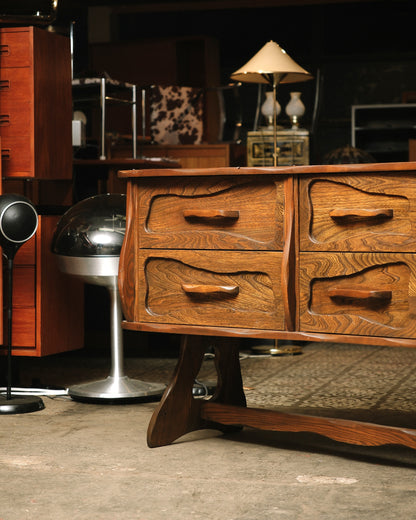 Detail of the dresser's lower drawers and sculpted trestle-style leg base.