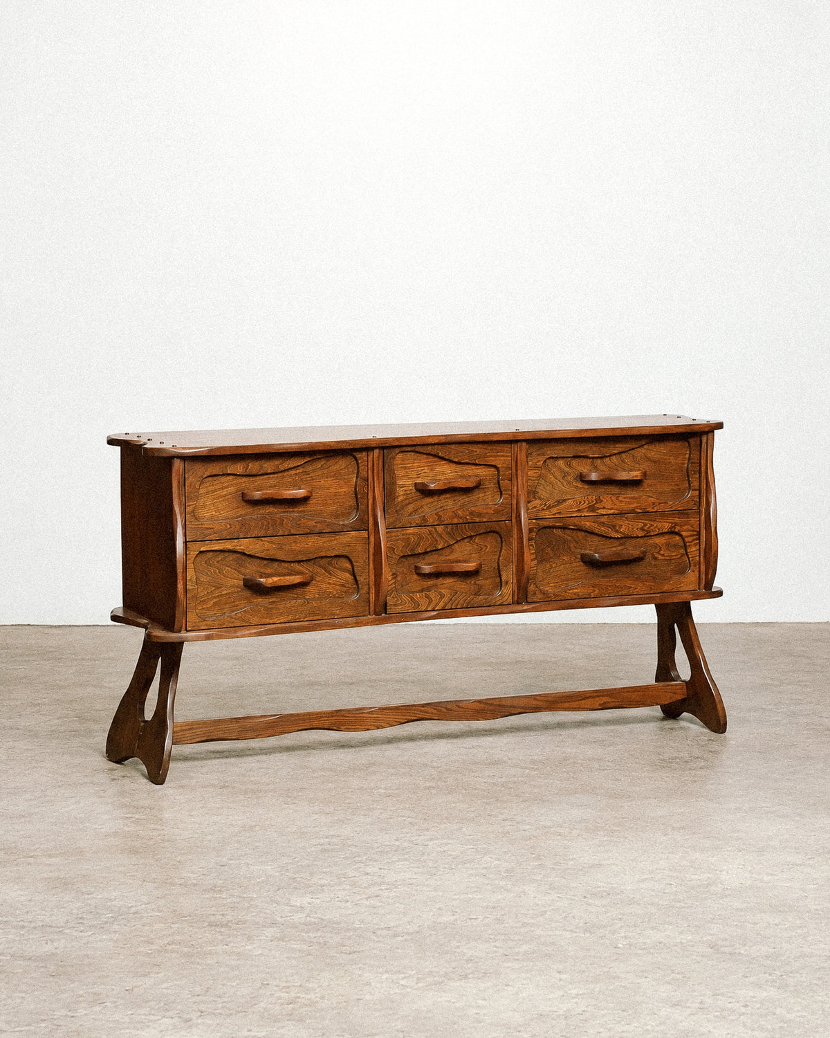 Side angle view showing the depth and sculpted silhouette of the dresser.