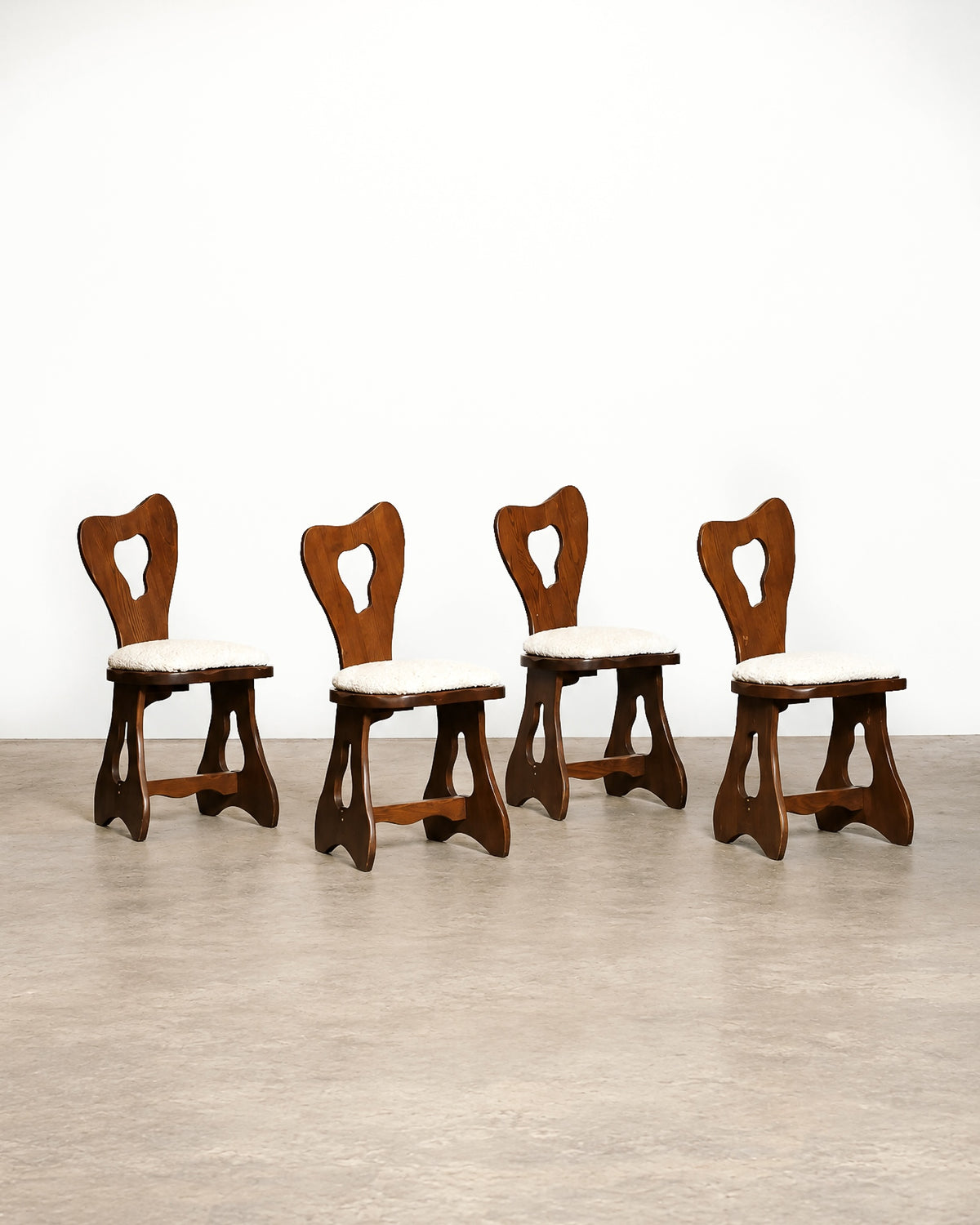 Close-up of a boucle-upholstered chair seat and solid oak frame with visible wood grain.
