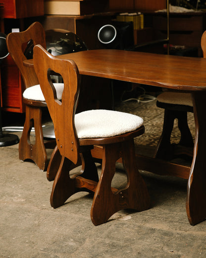 Close-up of a boucle-upholstered chair seat and solid oak frame with visible wood grain.