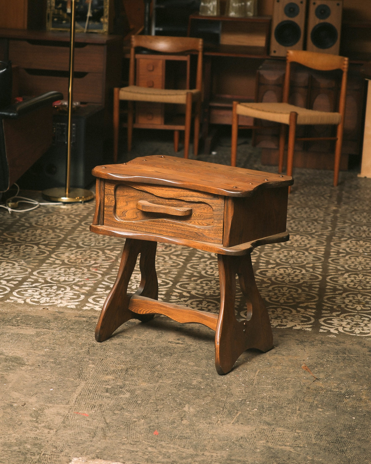 Vintage brutalist oak nightstand by Artisanat Renel, angled view showing drawer and trestle legs.