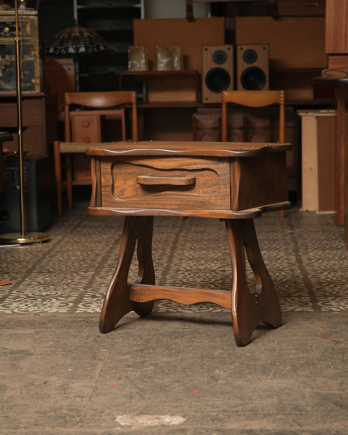 Front view of the brutalist oak nightstand with sculpted drawer pull and peg-accented top.
