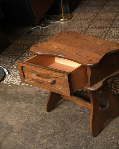 Close-up of the open drawer showing the carved wooden pull and interior construction.