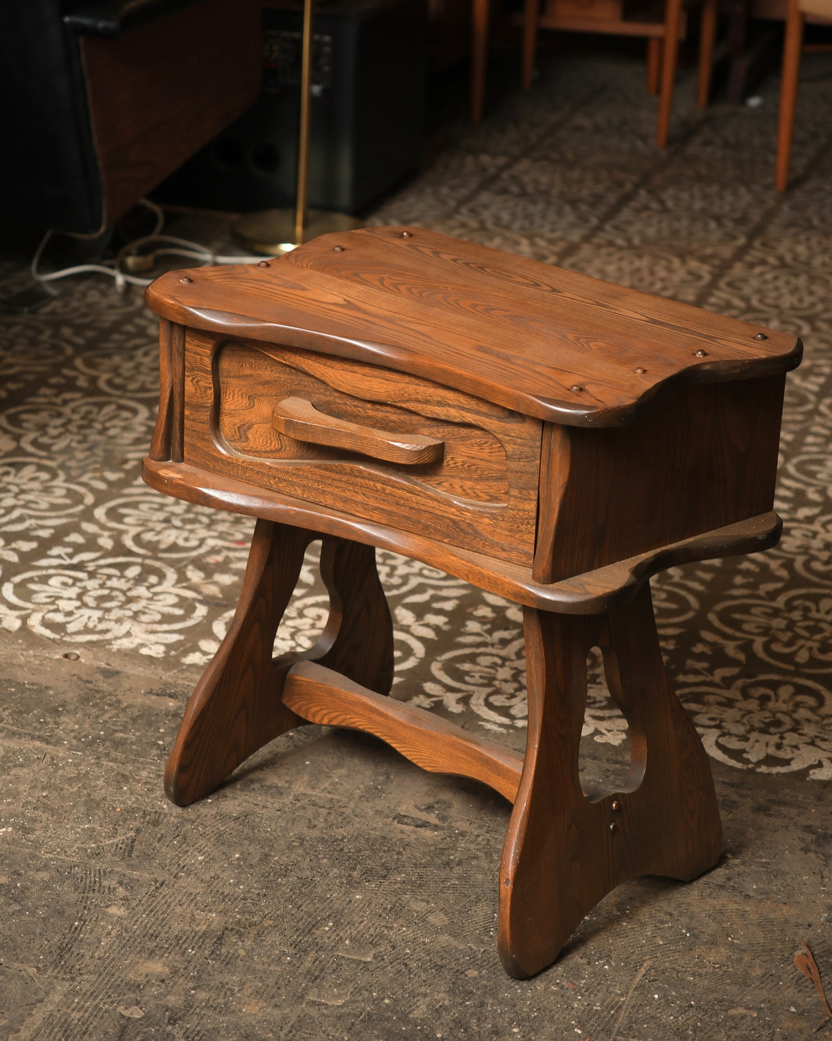Side angle view of the nightstand showing the trestle base and cross stretcher.