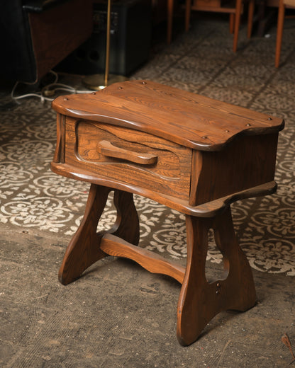 Side angle view of the nightstand showing the trestle base and cross stretcher.