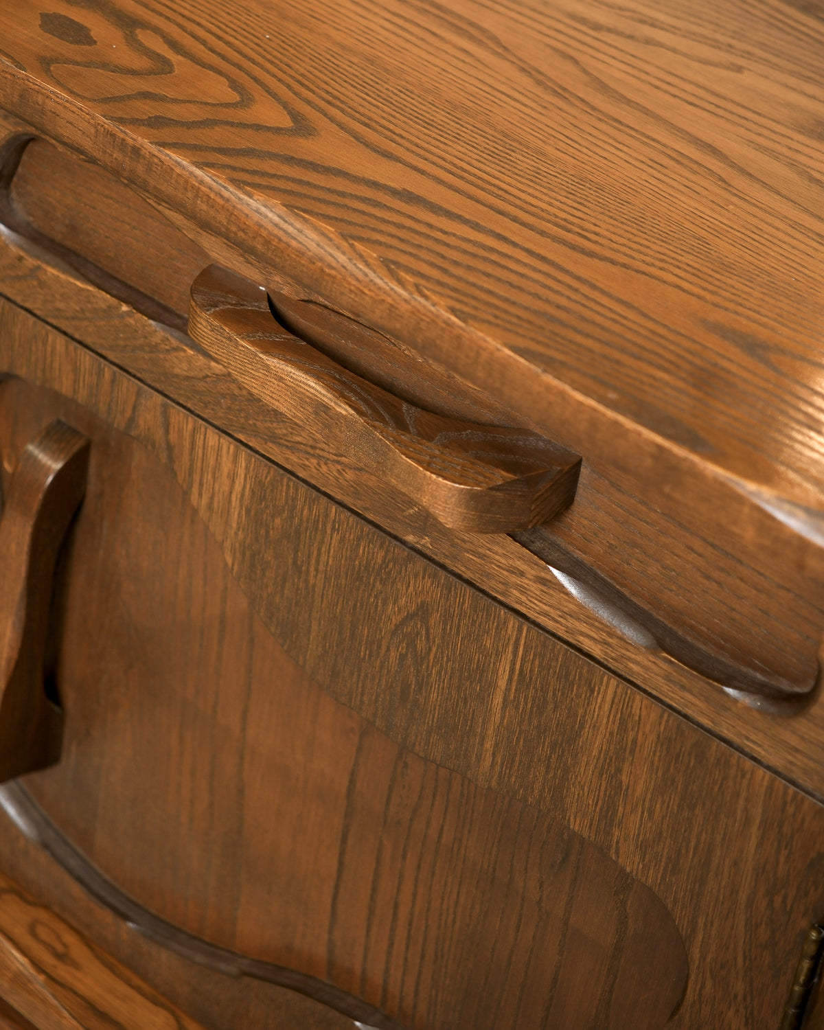 Close-up of a carved oak drawer pull and top edge detail on the brutalist sideboard.