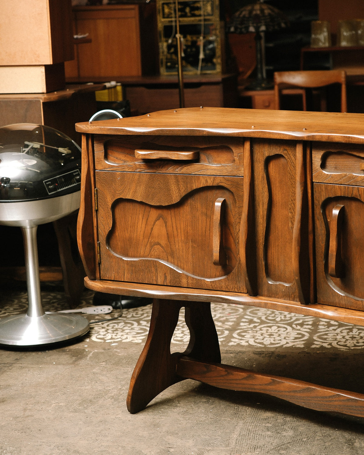 Close-up of the sideboard's corner, carved pulls, and trestle leg detail.