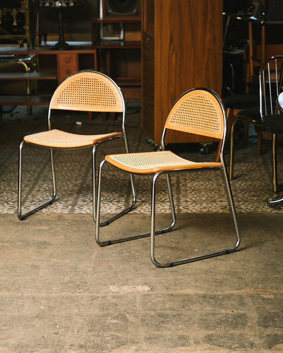 Front view of two cane chairs with chrome tubular frames on a patterned floor