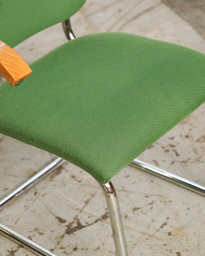 Close-up of the green fabric seat and chrome cantilever leg of the Cesca-style chair.