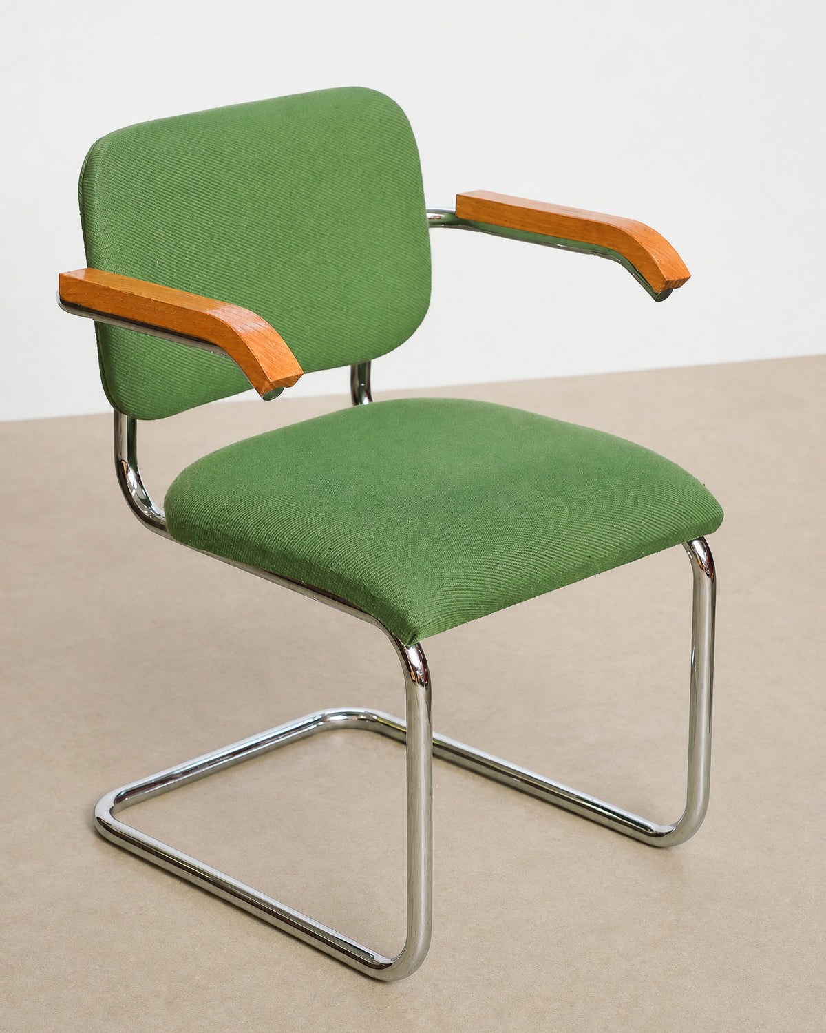 Front three-quarter studio view of the Cesca-style chair showing the full green upholstery and chrome frame.