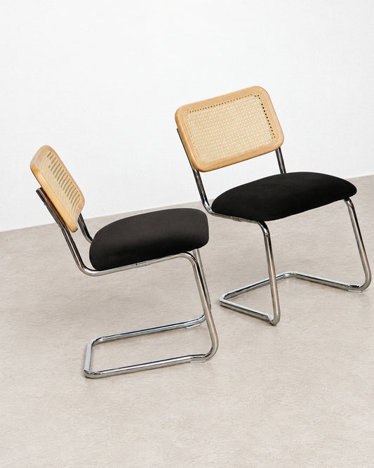 Two Cesca-style chairs shown back to back, highlighting the cane backrest and chrome cantilever legs