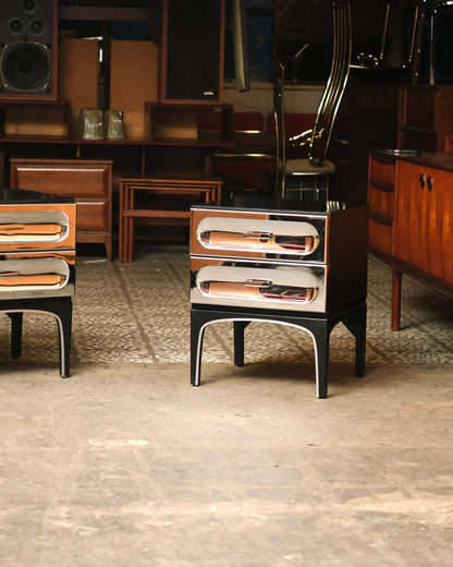 Pair of chrome bedside tables shown together in a vintage furniture showroom.