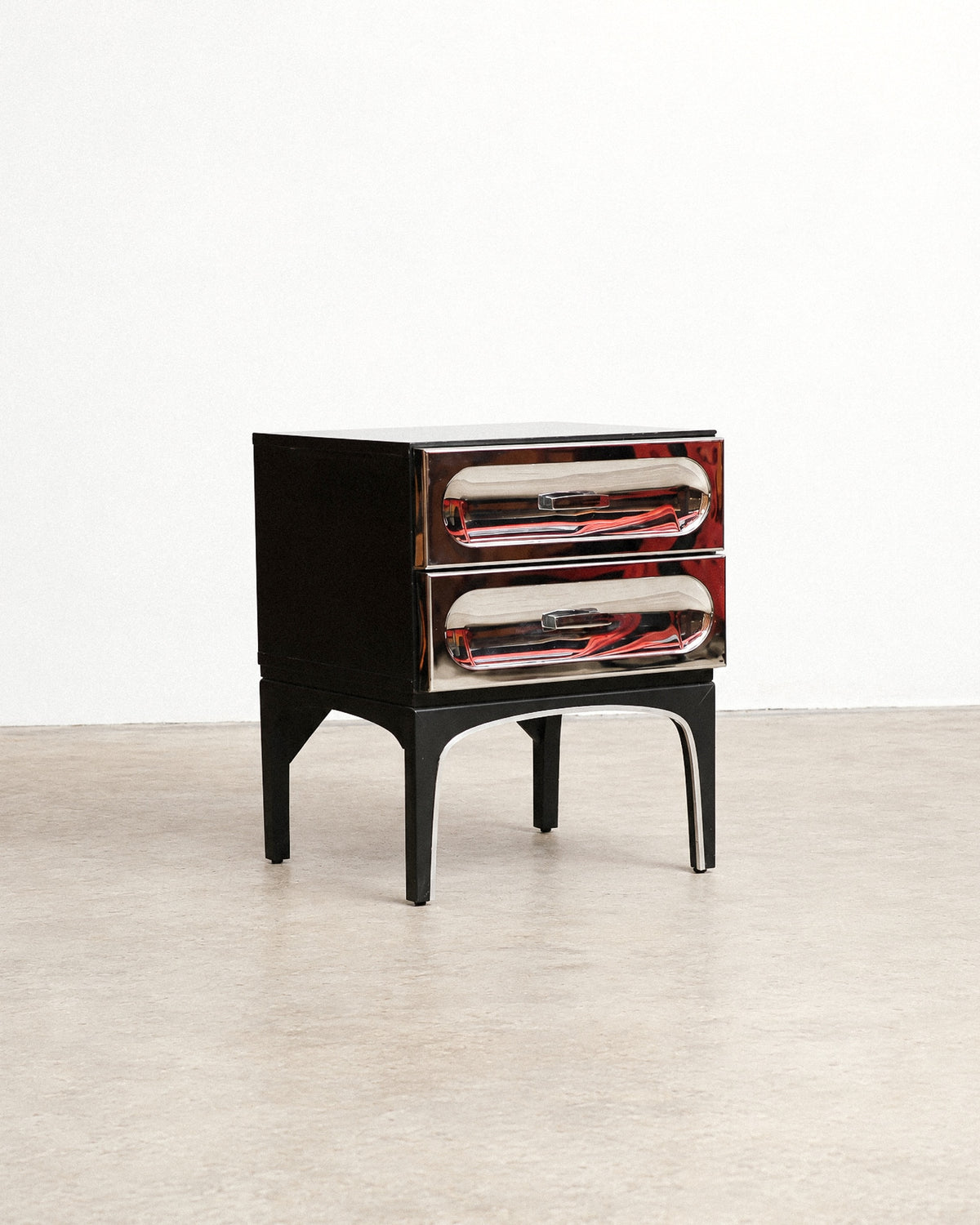 Studio side view of the chrome bedside table on a plain background.