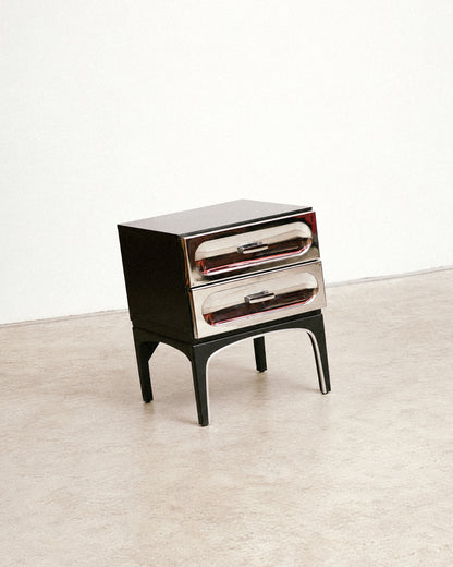 Studio angled view showing the top, chrome drawers, and arched leg detail.