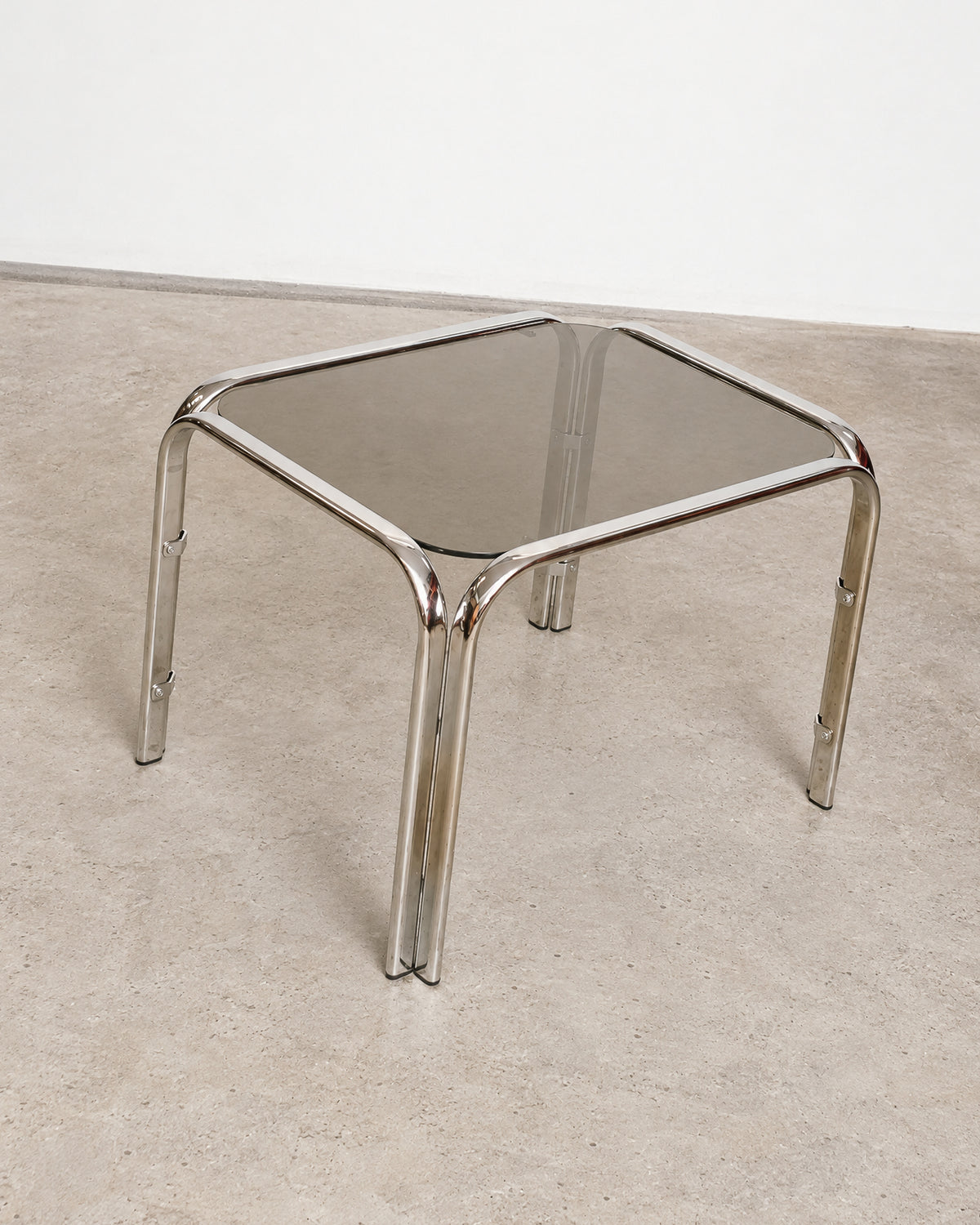 Overhead angle of the chrome coffee table showing the smoked glass top and tubular legs.