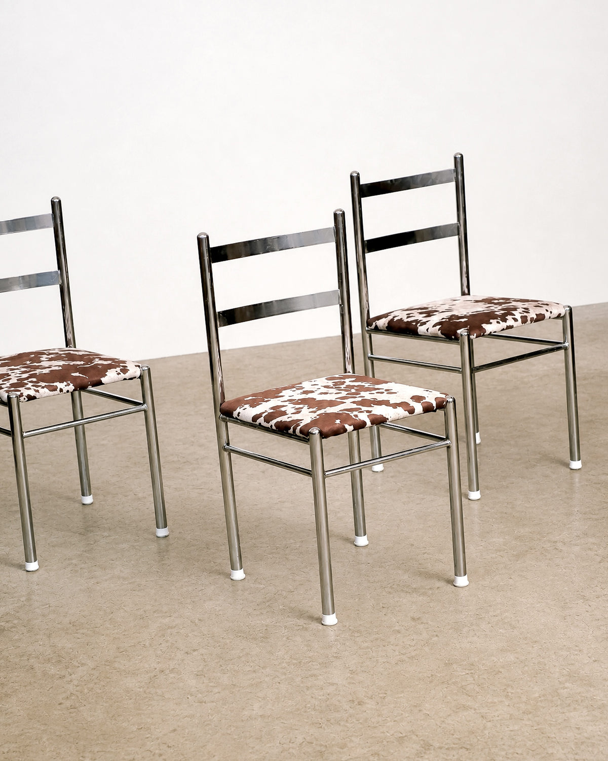 Additional angle of the chrome chair highlighting the ladder-back detail and tubular legs.