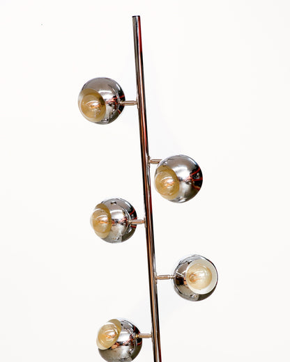 Close-up of five chrome eyeball light heads branching off the central pole of a vintage floor lamp.