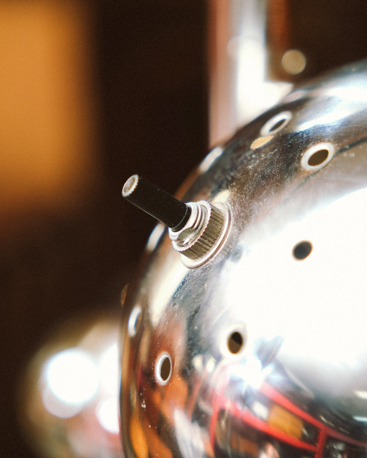 Close-up of the individual toggle switch on the back of one chrome eyeball lamp shade.