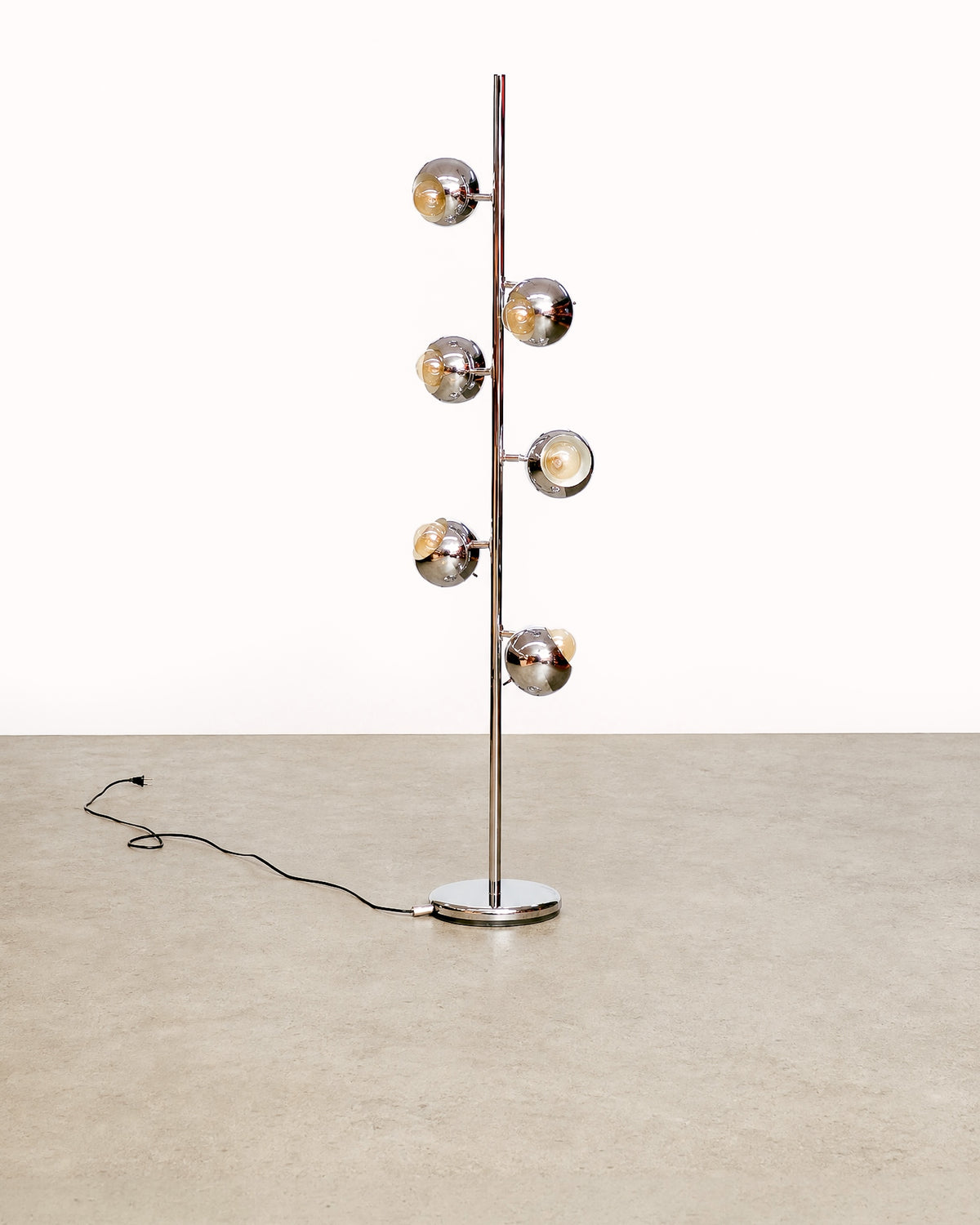 Front view of the vintage chrome floor lamp standing straight, showing the full height and base with cord.