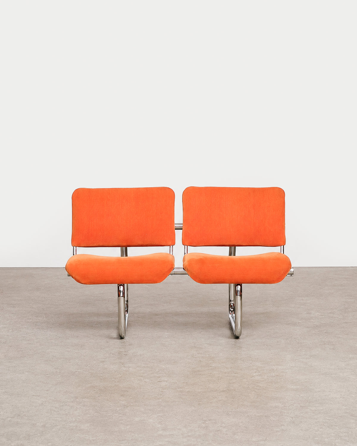 Detail of the orange velvet upholstery texture on the chair seat.