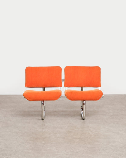 Detail of the orange velvet upholstery texture on the chair seat.