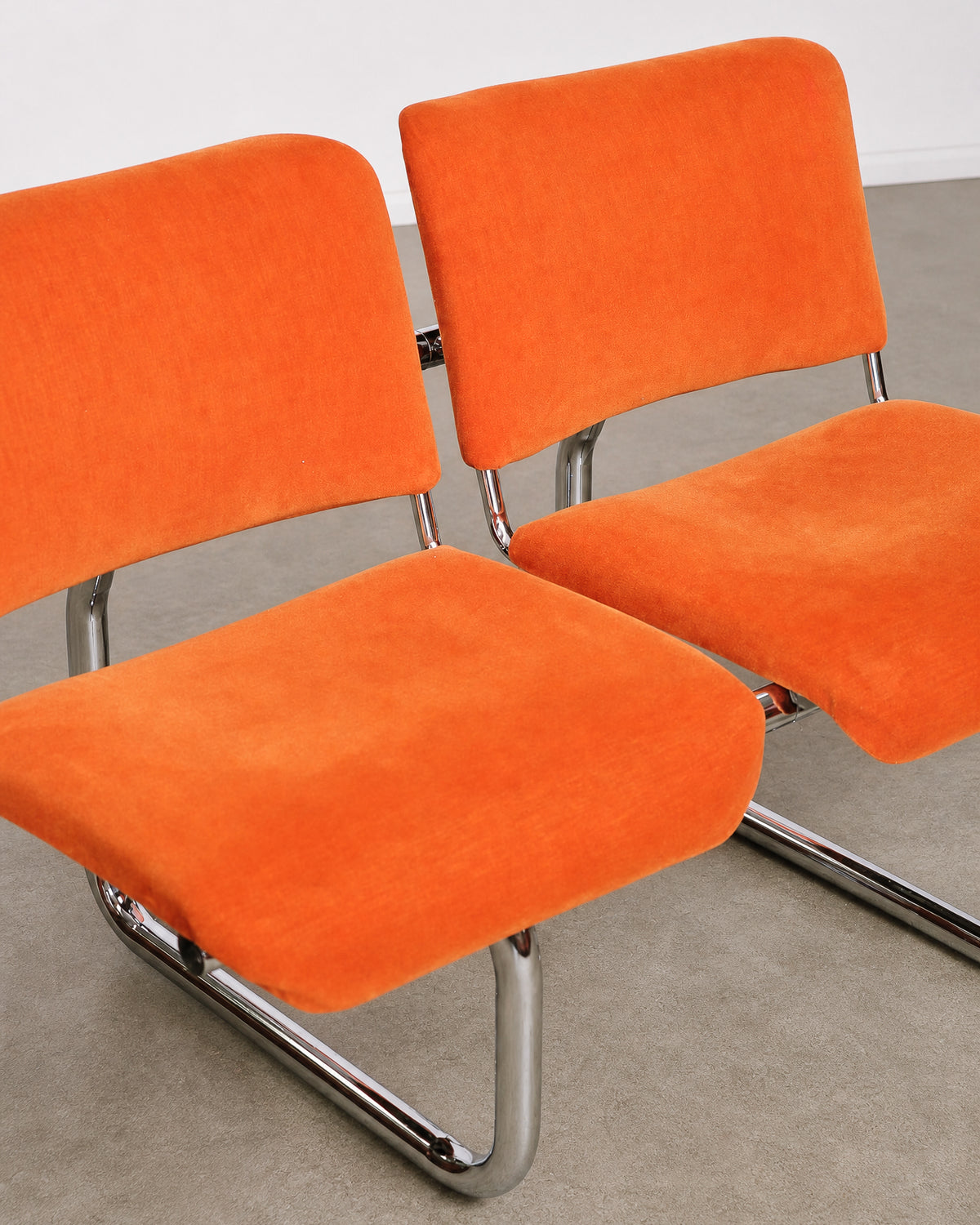 Wide shot of the orange tubular chairs among other mid-century pieces in the shop.