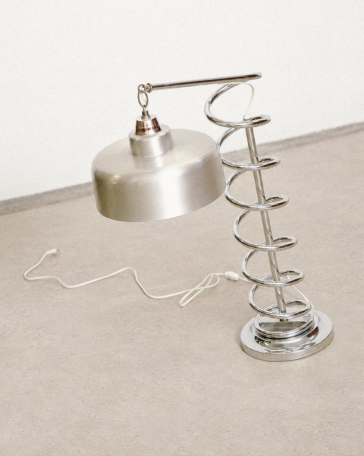 Angled view of the chrome spiral lamp highlighting the shade and adjustable arm