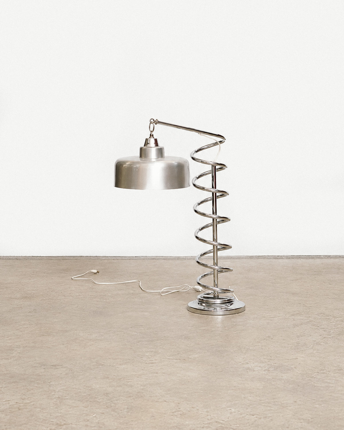 Front view of the chrome spiral table lamp against a plain backdrop showing overall form