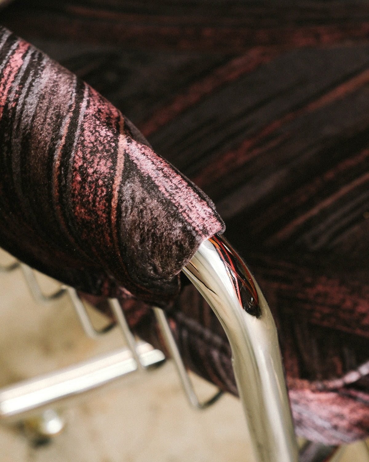 Detail of chrome armrest joint with patterned upholstery fabric wrapped over the tube frame