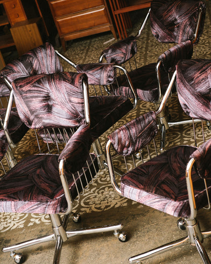 Overhead angled view of multiple chrome swivel armchairs showing patterned upholstery and wire backs